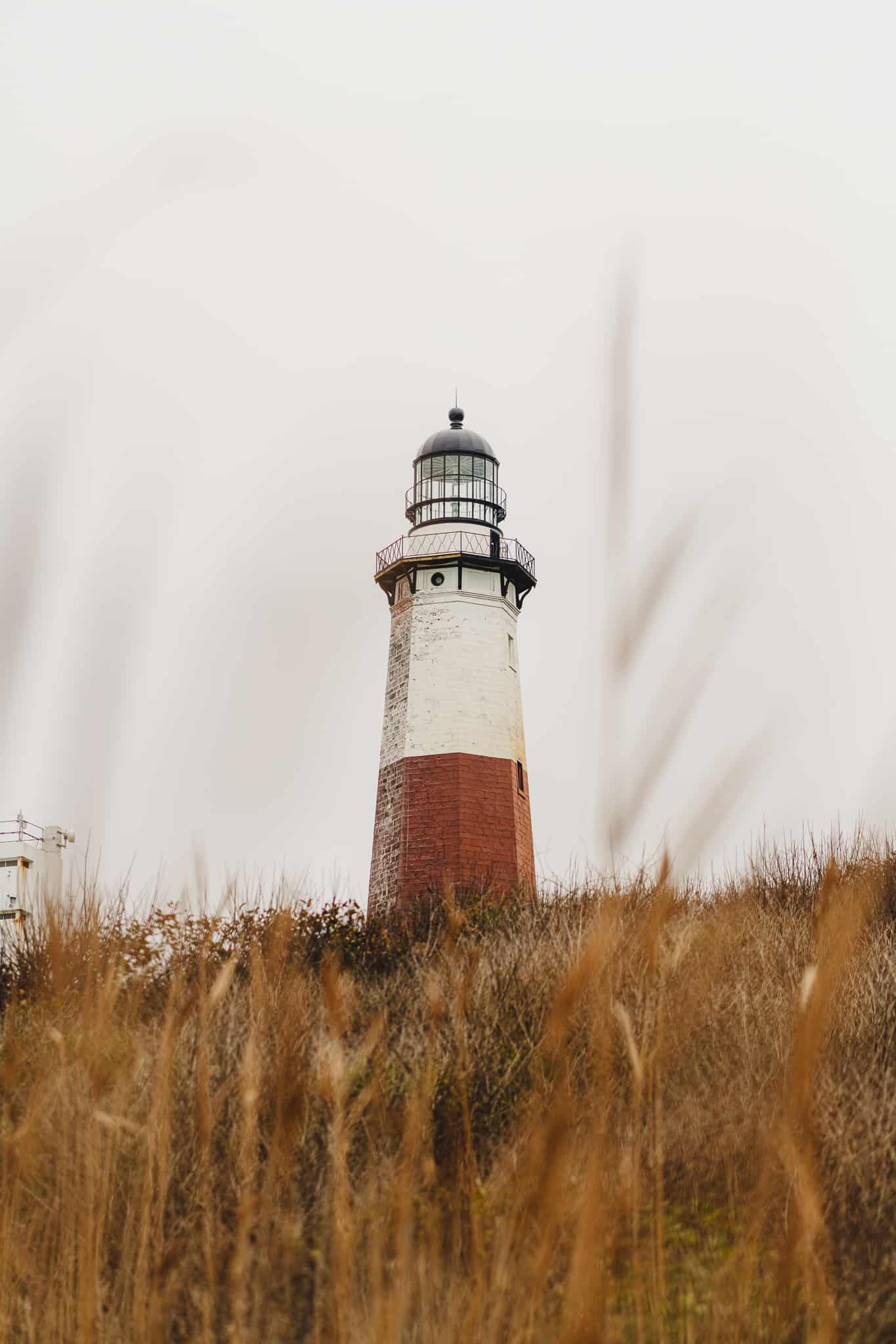 A portrait of the Montauk lighthouse on a gloomy day in Long Island New York with warm grass Franz in the front