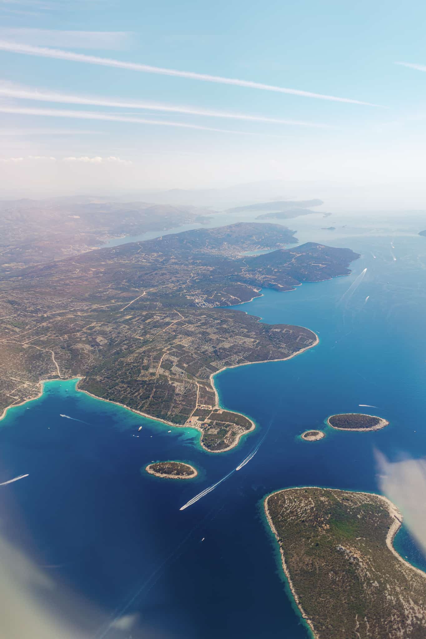 An overhead photo while flying over the Adriatic coast of split Croatia. Boats are driving through the crystal blue water