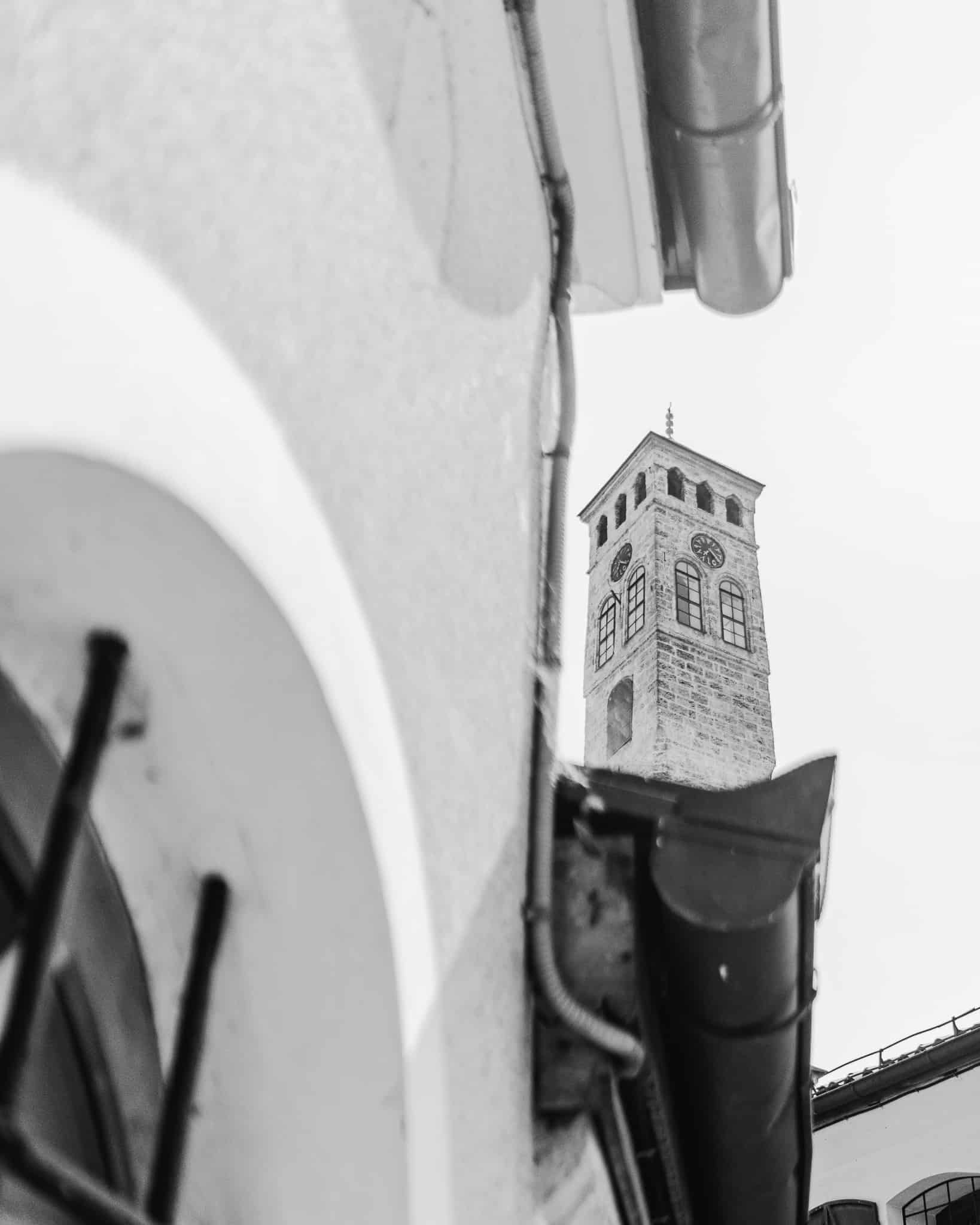 Black and white photo of the old Sarajevo clock tower which keeps track of lunar time