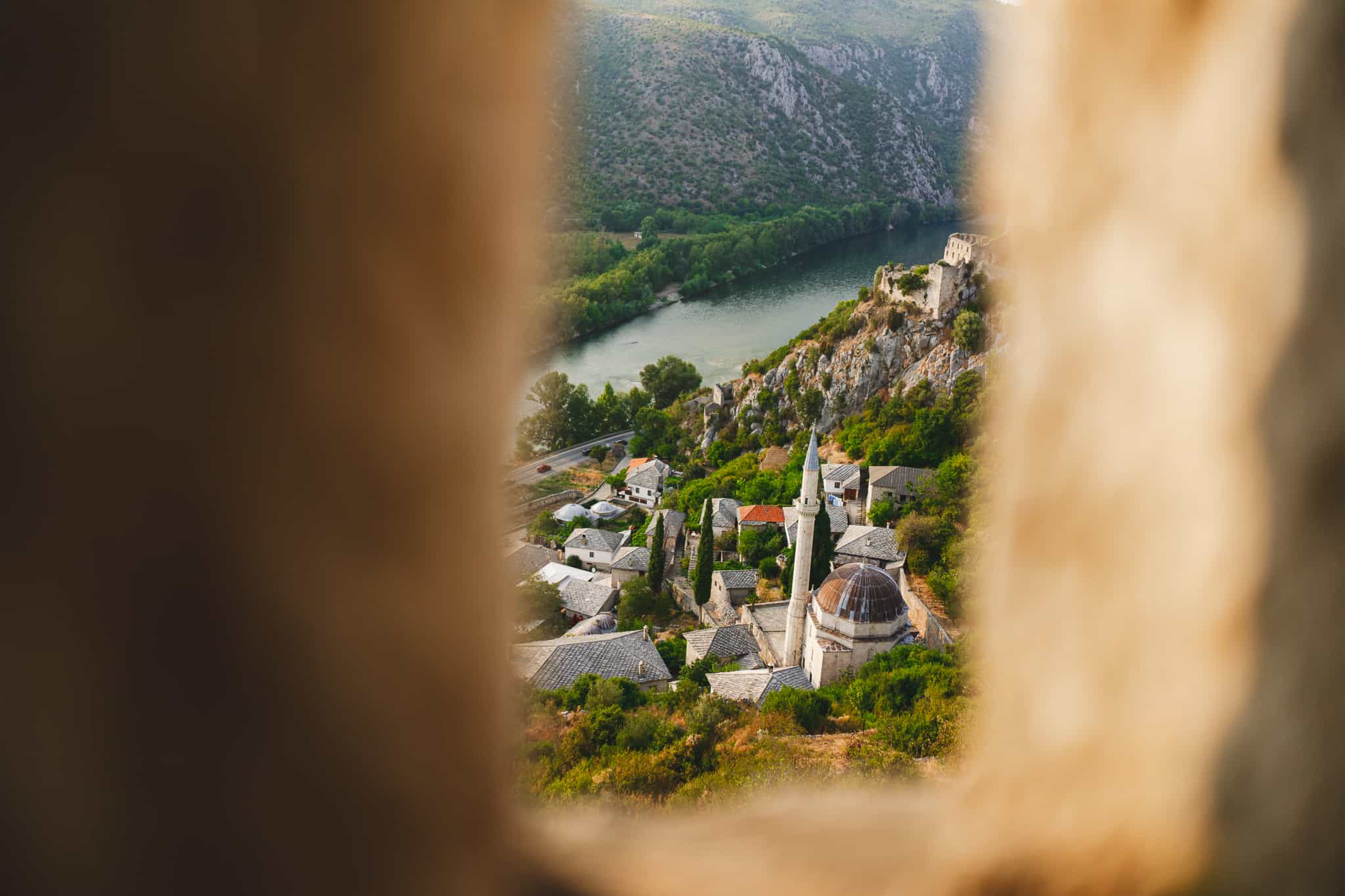 The buildings in the hillside surrounding Stjepan Grad - Blagaj Castle shot through a slit in the walls of the castle