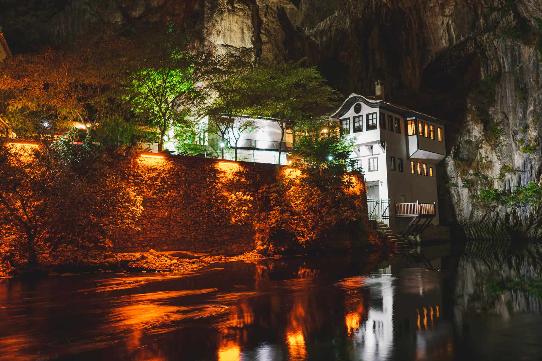 wide night time photo of Blagaj Tekija, Bosnia's Beautiful Monastery Under A Cliff