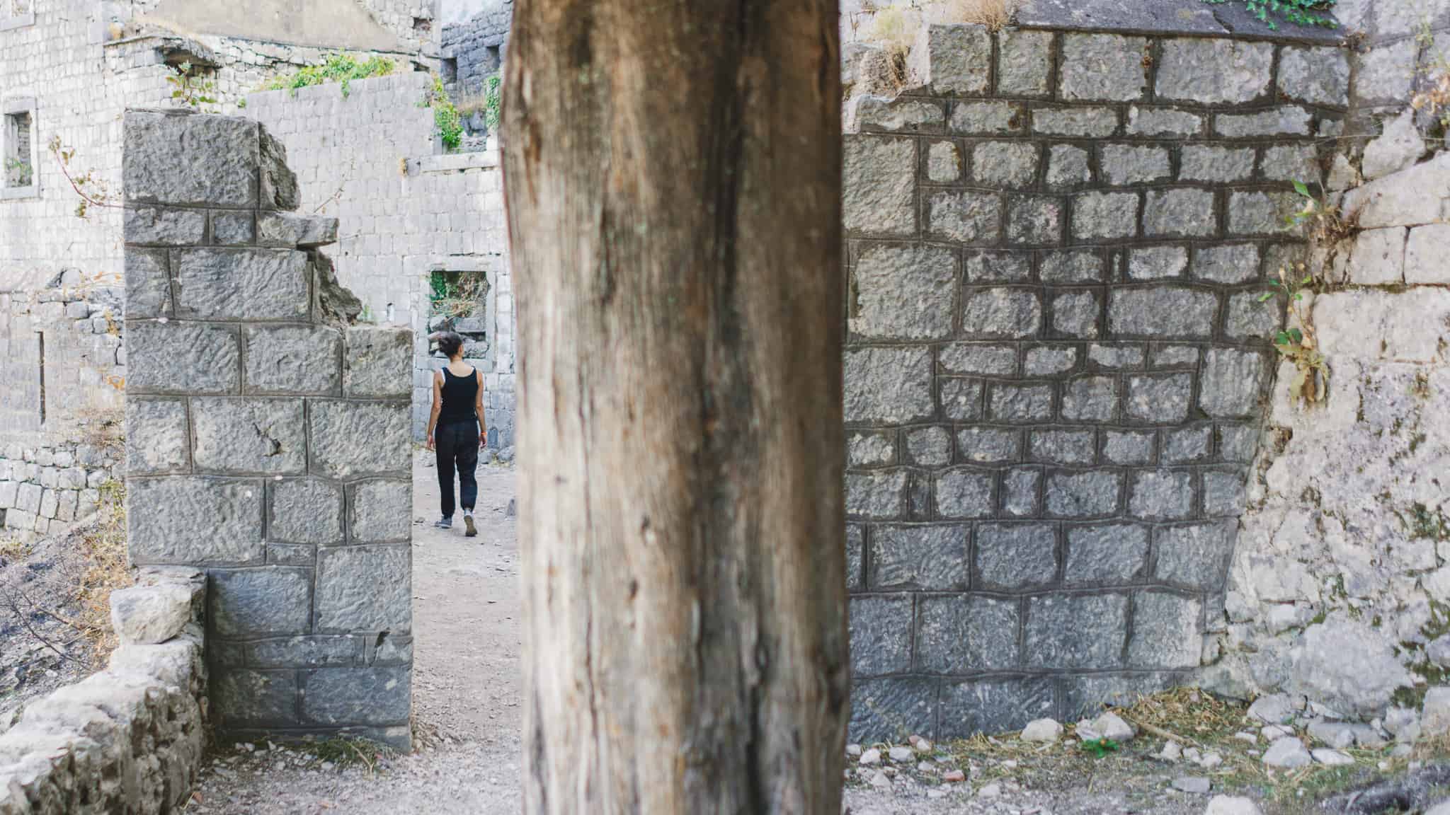 Walking through the ruins of the castle of San Giovanni after hiking the ladder of kotor in Montenegro