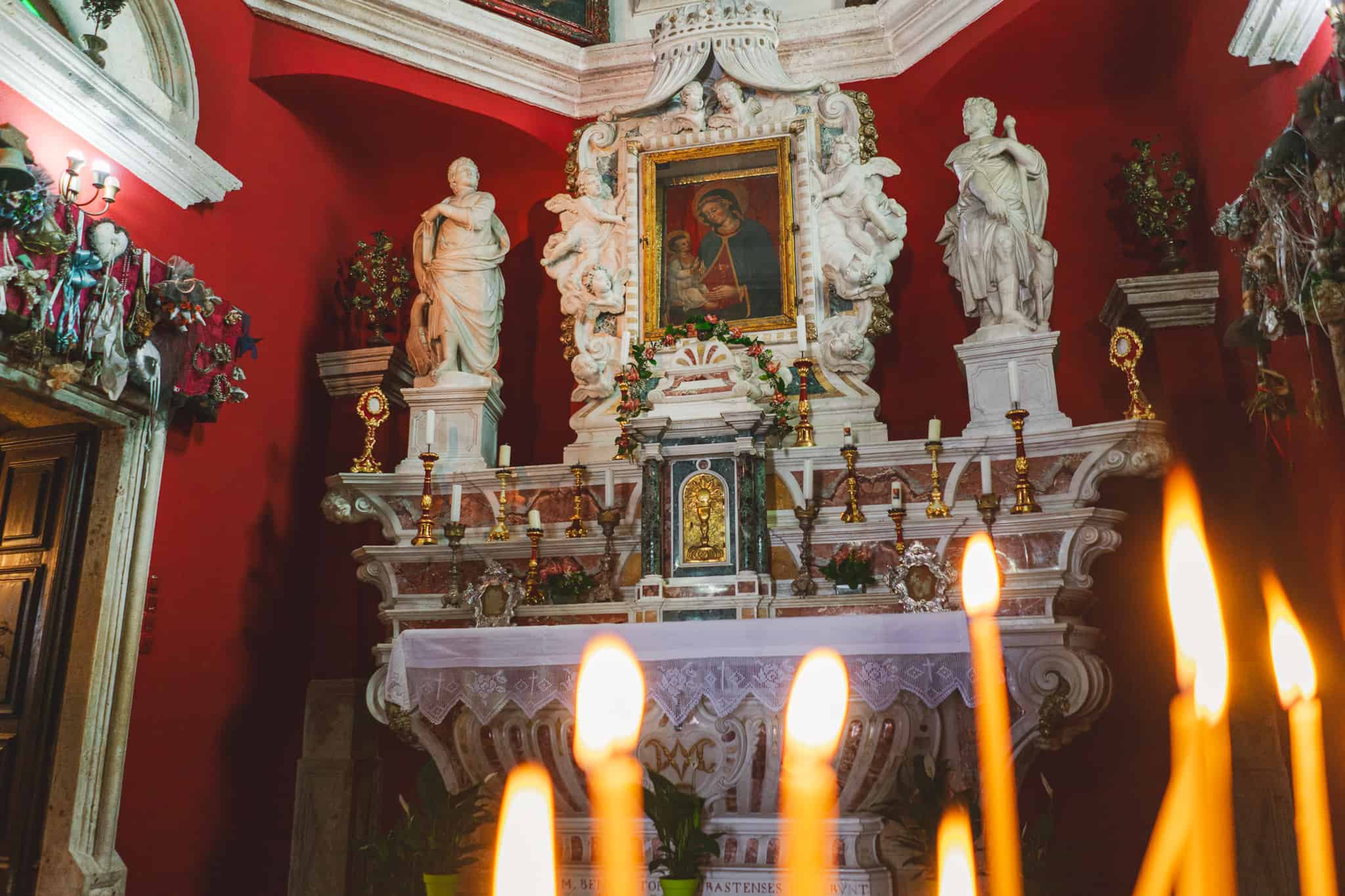 Photo of a shrine with blurred candles in the foreground while at the tiny church on "Our Lady of the rocks" off the coast of Kotor