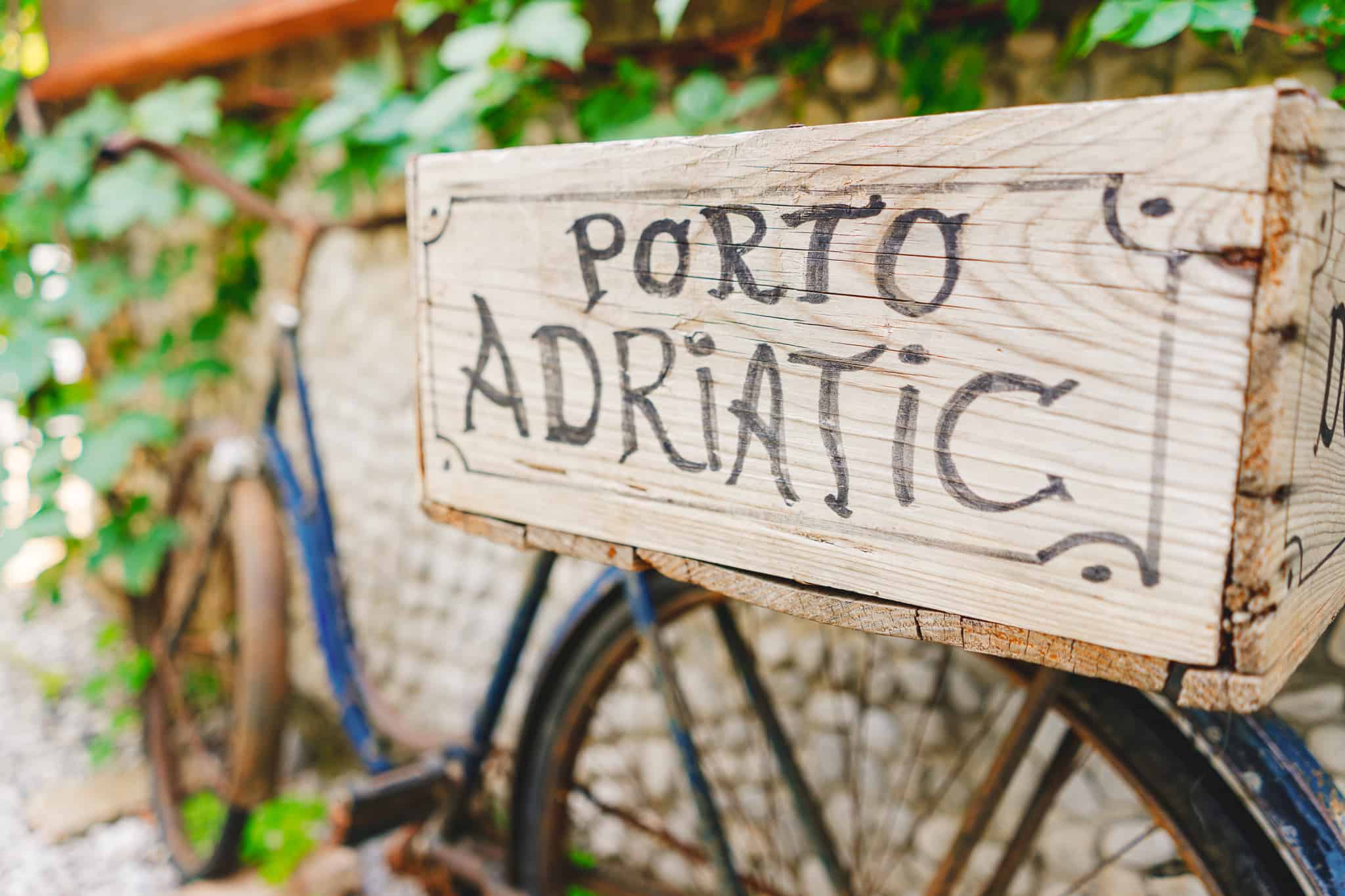 Photo of a Mediterranean bicycle with a wine box on the back that says Porto Adriatic shot in Kotor Montenegro