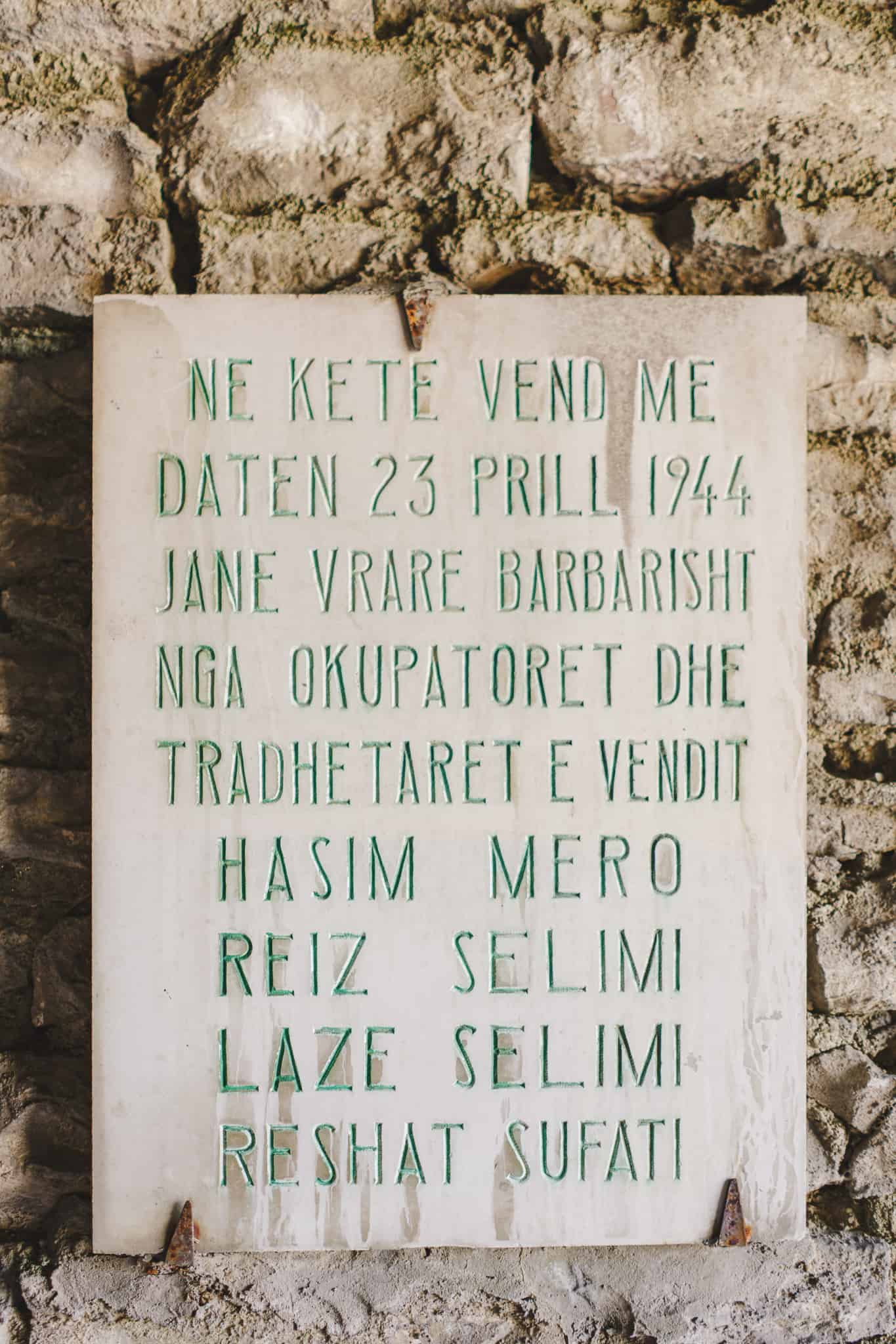 a stone sign with green lettering at the national armaments museum in gjirokaster Albania