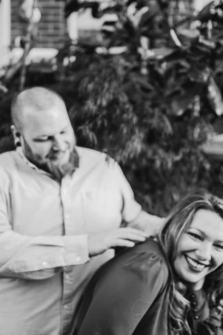 Black and white artsy blurred photo of cute couple laughing and tickling during their engagement session in Fishtown Philly
