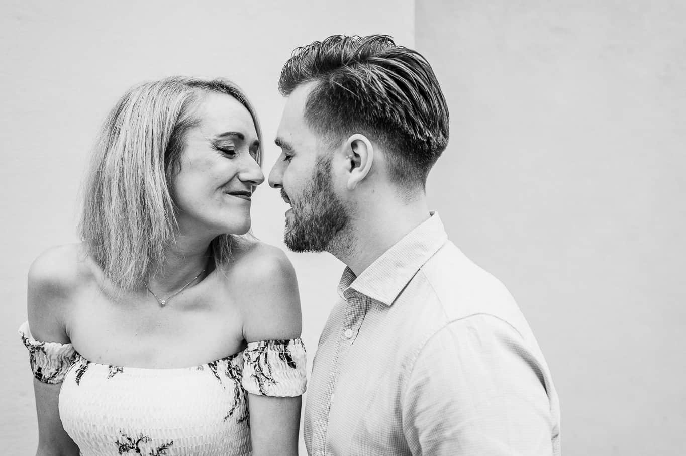 Couple touching noses and giggling during an engagement photoshoot in black and white in Rome Italy